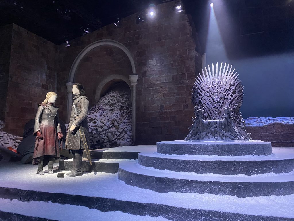 Costumes de Daenerys Targaryen et Jon Snow exposés devant le Trône de Fer aux studios Game of Thrones