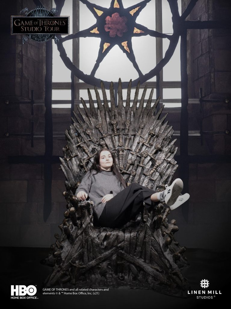 Visiteur assis sur le Trône de Fer dans la boutique des studios Game of Thrones